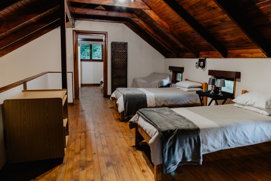 Two single beds in the spacious loft area leading to private bedroom 1 at The Wooden Forest House