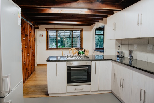 Fully equipped self-catering kitchen with gas kettle, stovetop, oven, toaster, microwave, fridge at The Wooden Forest House