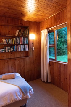 Single bed in a log cabin styled bedroom 3 with plenty reading material at Natures Way Farmhouse