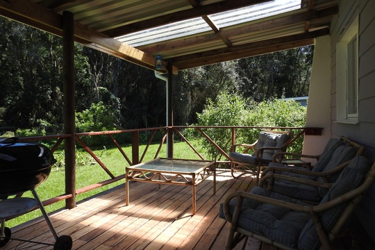 Beautiful wooden back deck with seating for 4 and weber with forest views, ideal for birding at The Bush Buck Cottage