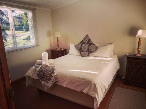 Spacious main bedroom with double bed and packing space at The Bush Buck Cottage
