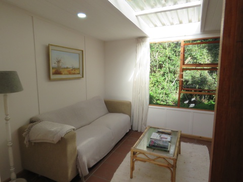 Bright and comfortable lounge with large sofa in The Bush Pig Cottage